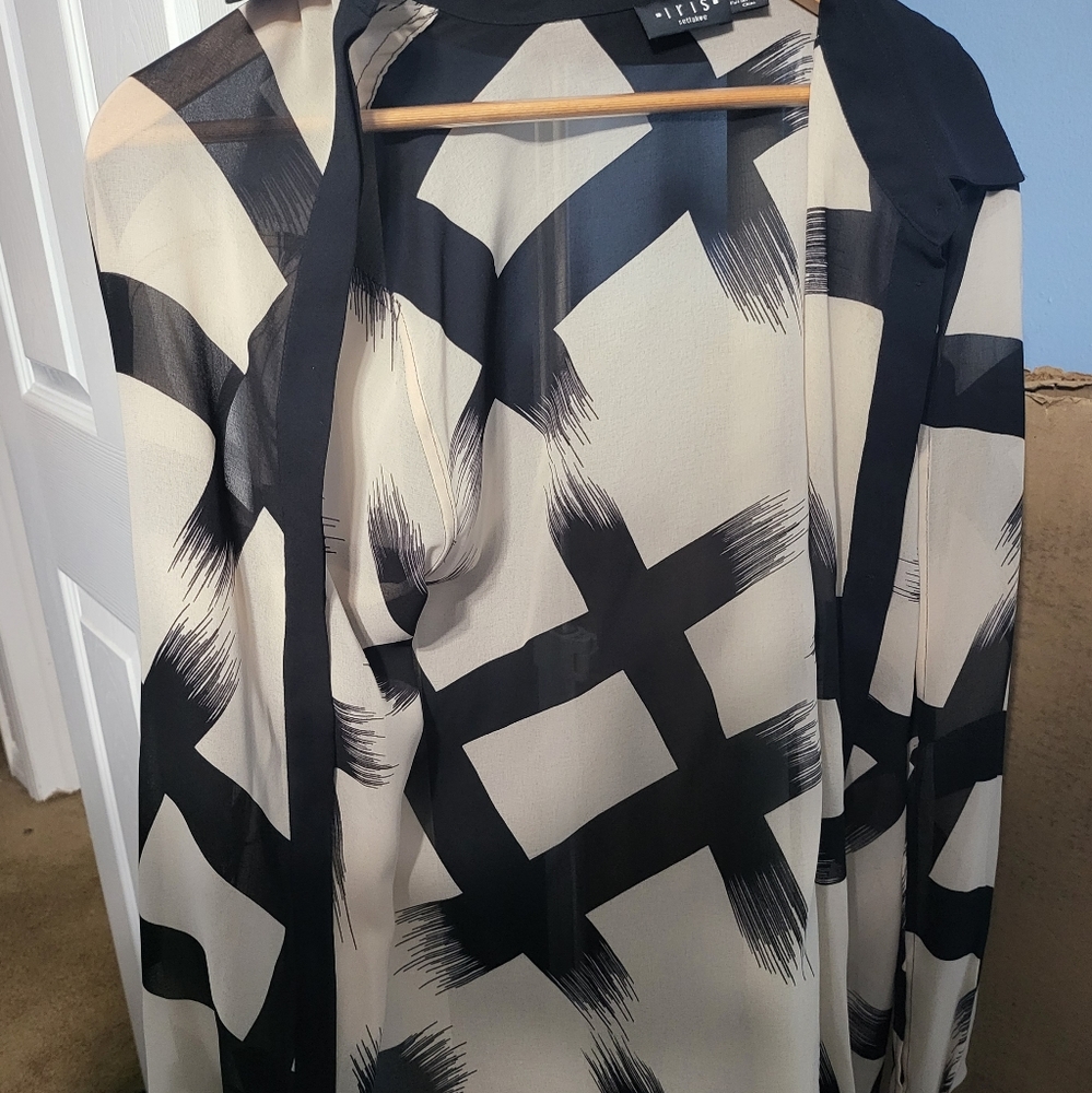 Beautiful beige and black top. Has 2 openings on each sleeve . Very flattering .